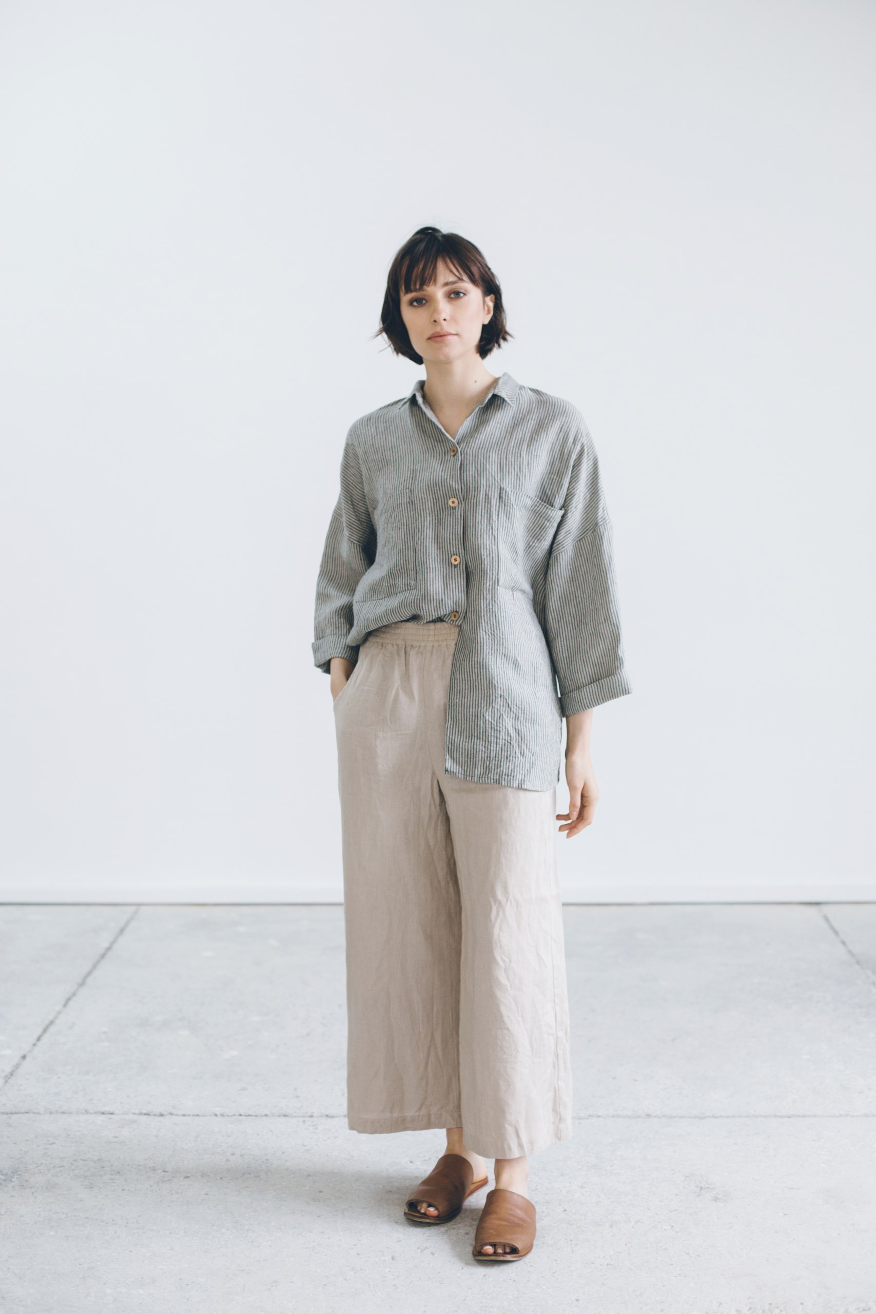 A woman in oversized 3/4 sleeve linen striped shirt