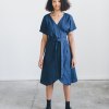 A woman wearing navy blue linen wrap dress