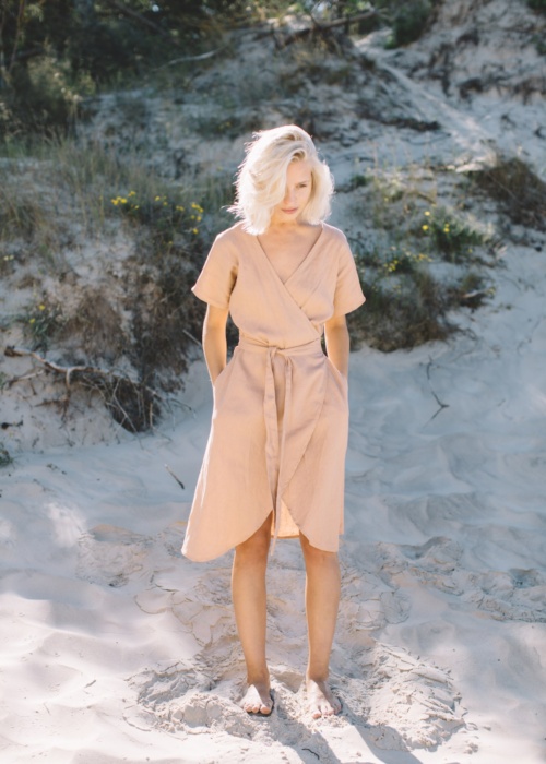 A woman in linen wrap dress in dusty peach