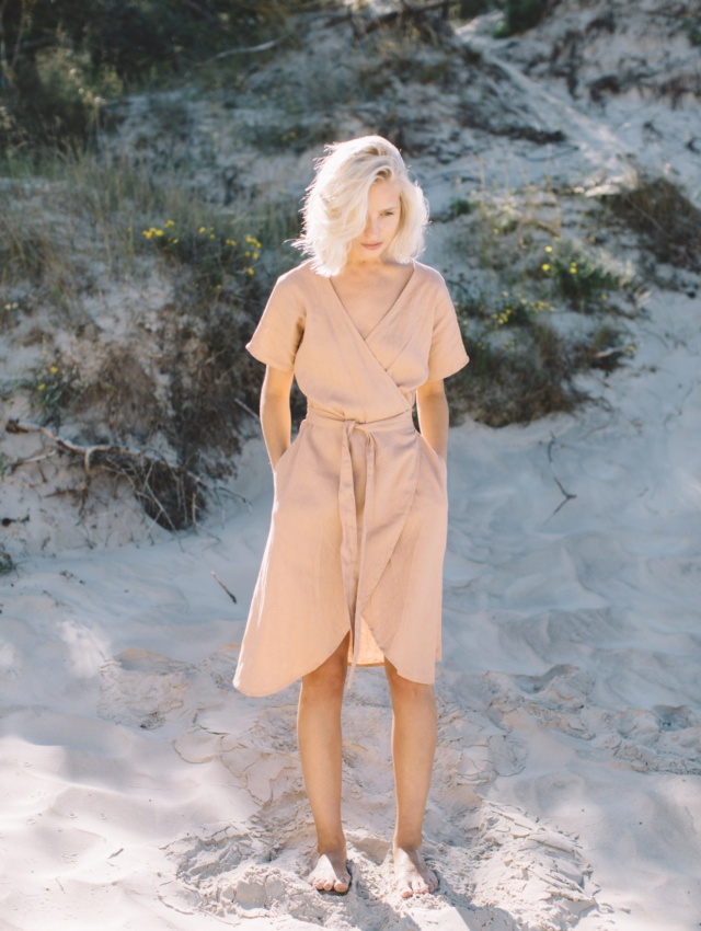 A woman in linen wrap dress in dusty peach