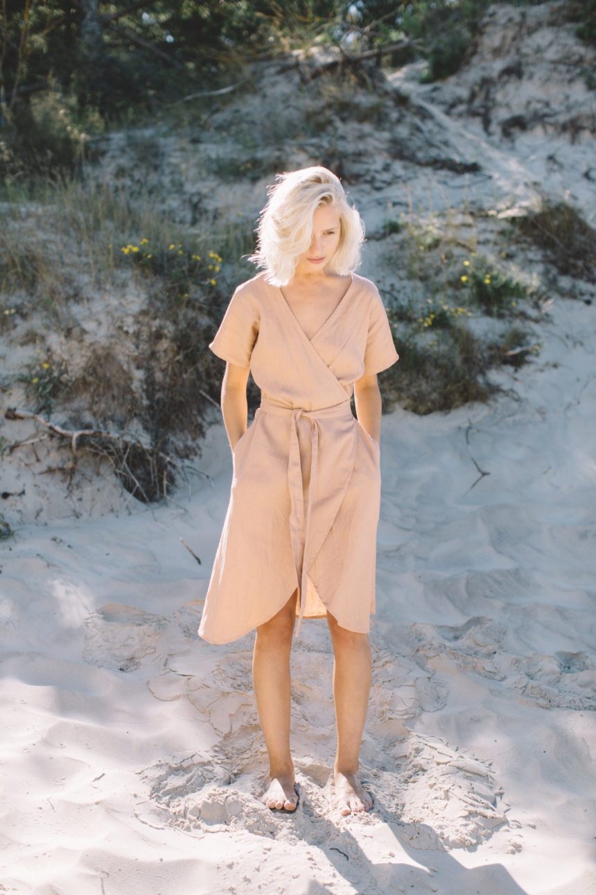 A woman in linen wrap dress in dusty peach