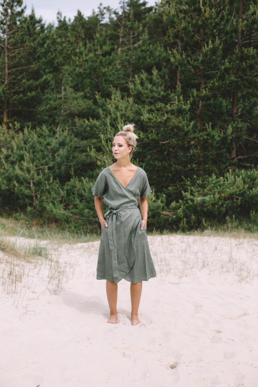 A woman wearing dark green linen wrap dress