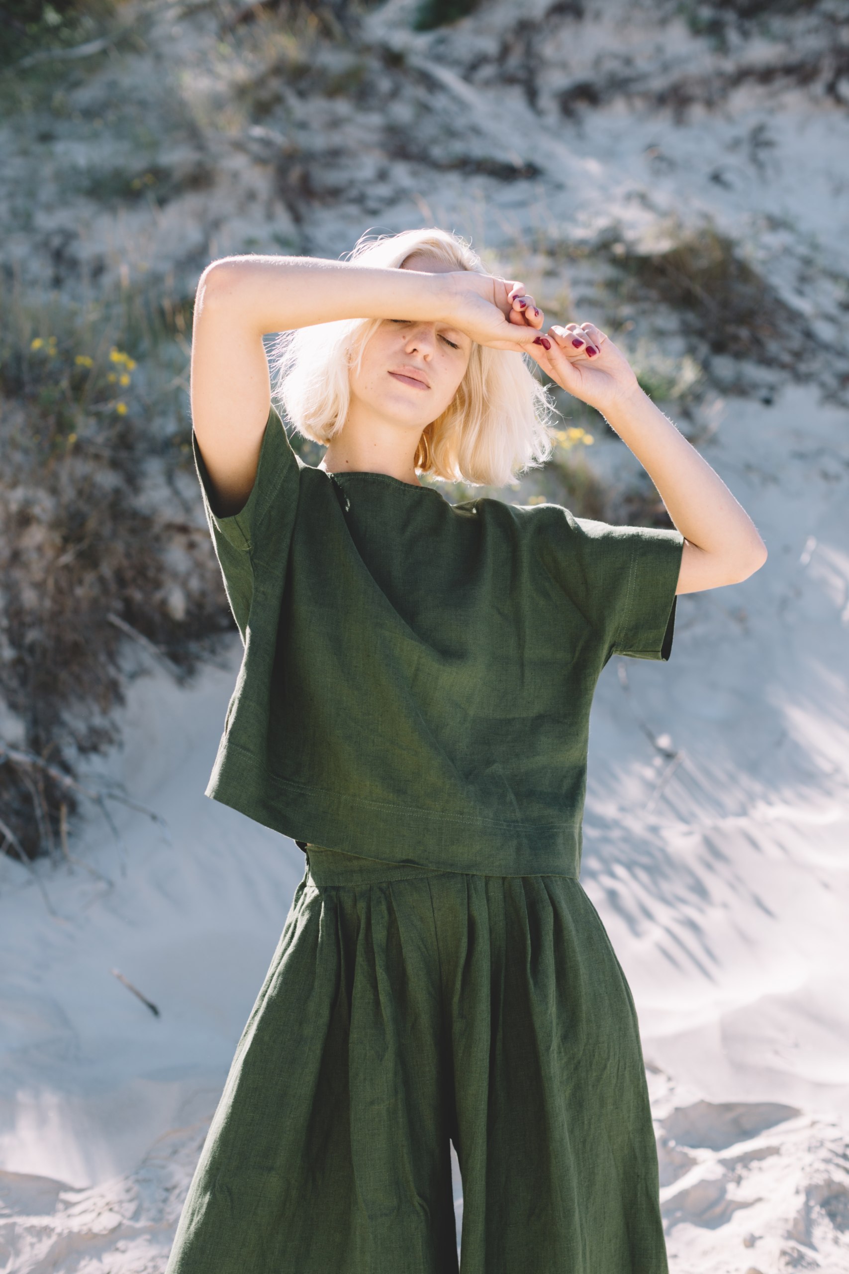 A woman in boxy dark green linen top