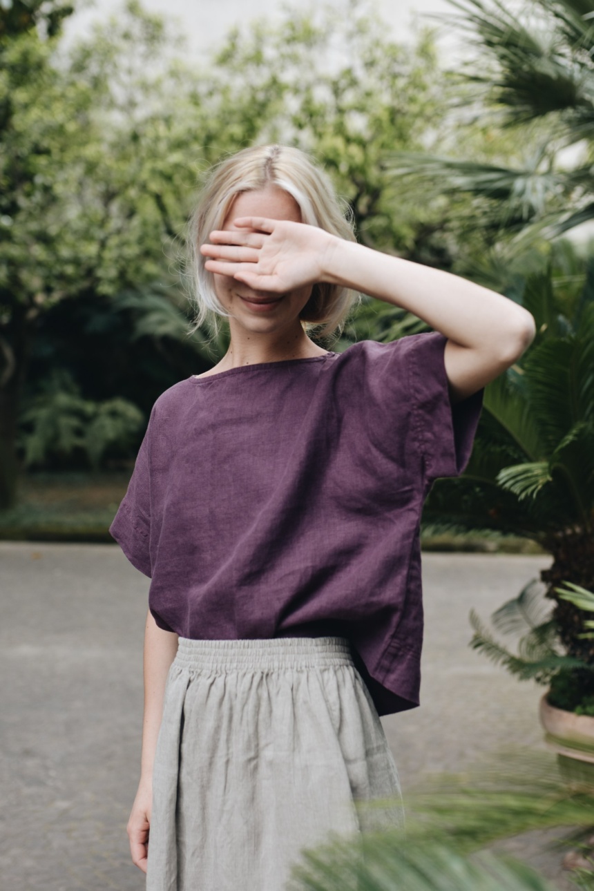 A woman wearing dark violet straight cut linen top