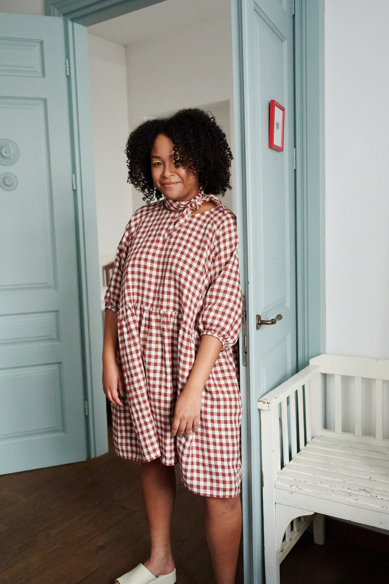 An oversized A-line terracotta gingham linen with quarter sleeves and gathered cuffs