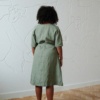 Back of an oversized green midi linen dress with wide sleeves