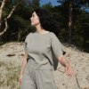 A woman in light grey oversized summer linen top