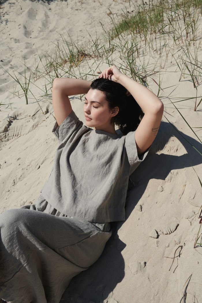 A woman wearing a grey oversized linen top