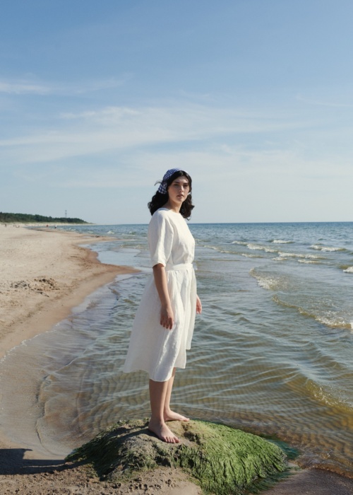 Lady by the sea wearing white dress