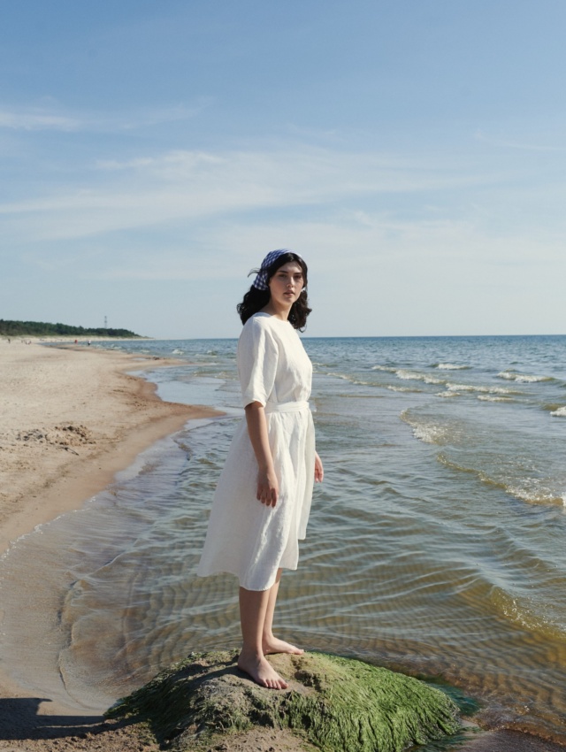 Lady by the sea wearing white dress