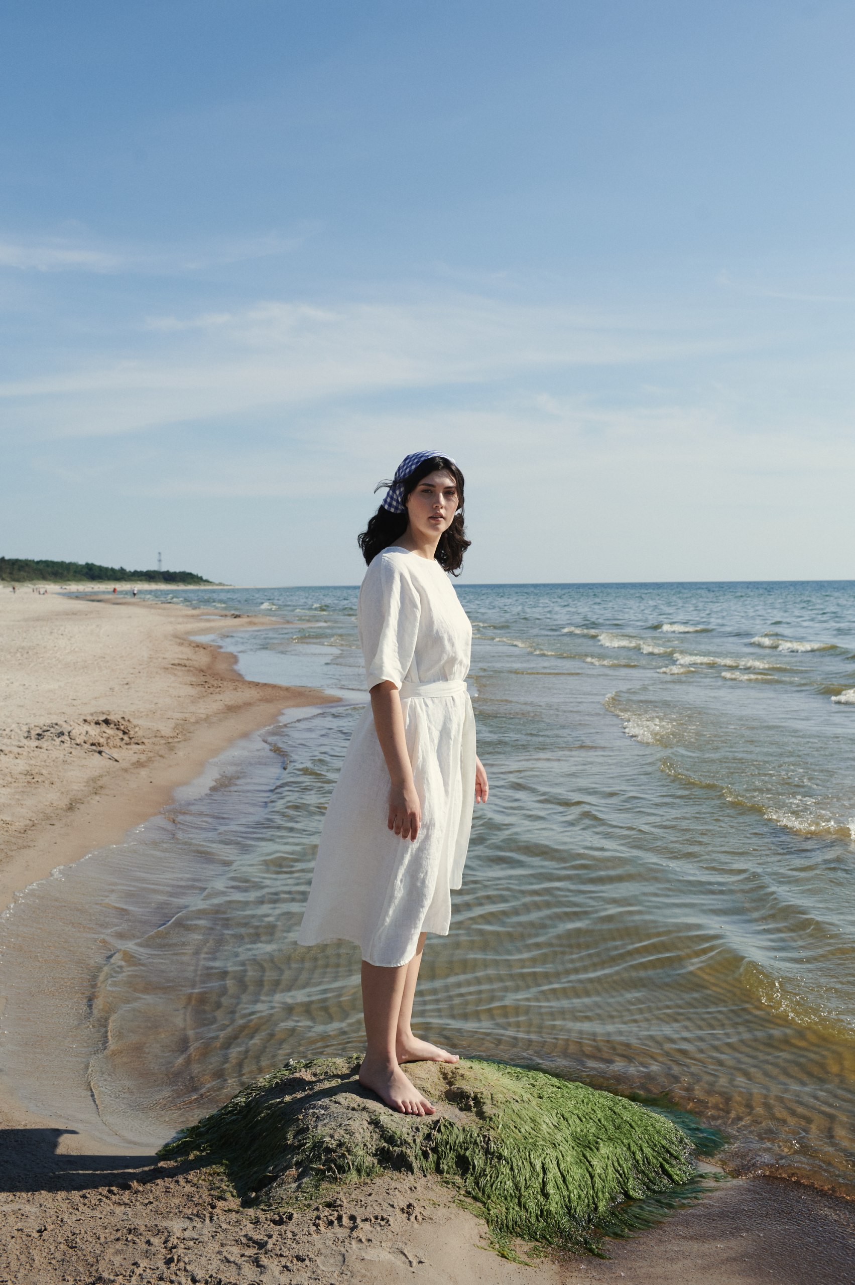 Lady by the sea wearing white dress