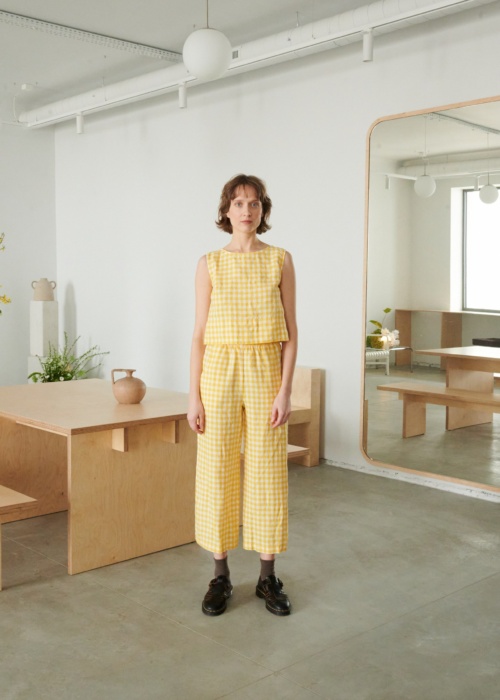 A woman in relaxed yellow gingham linen pants