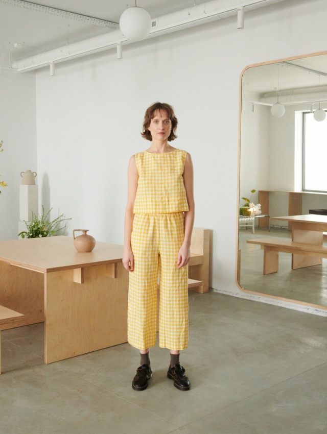 A woman in relaxed yellow gingham linen pants