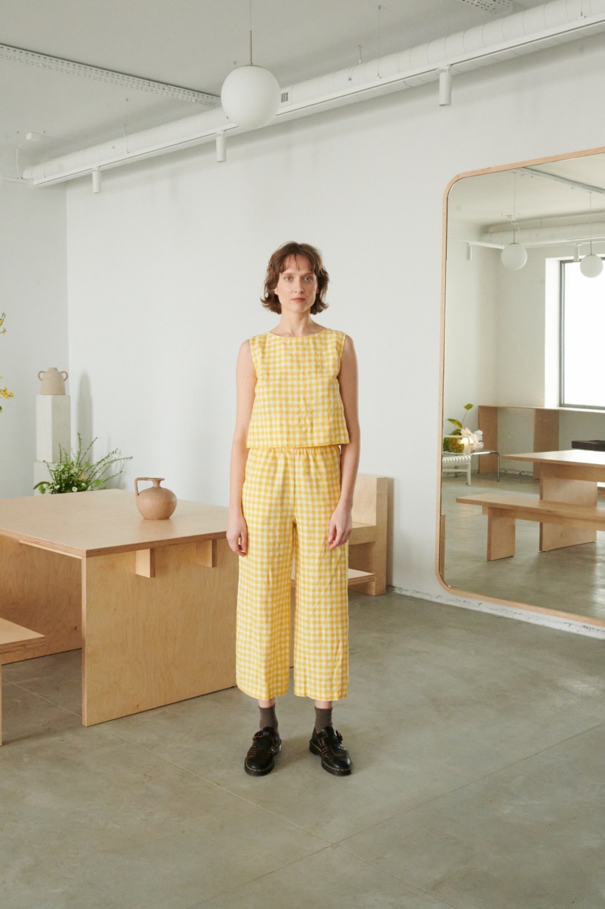 A woman in relaxed yellow gingham linen pants