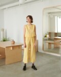 A model in yellow gingham high waist linen trousers and a matching top