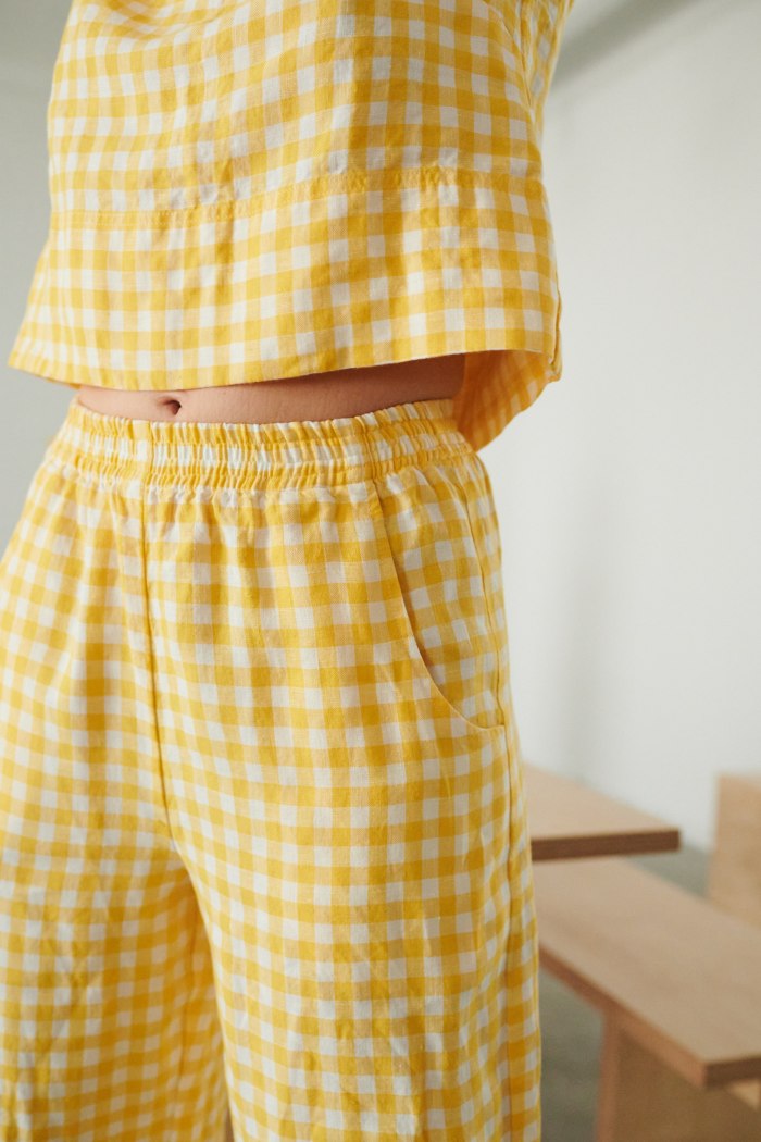 Elasticated waistband of yellow gingham wide leg linen trousers