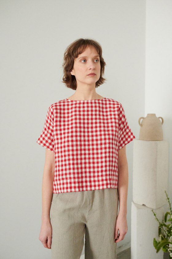 A woman in red gingham boxy linen top