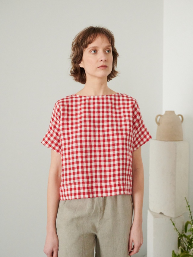 A woman in red gingham boxy linen top