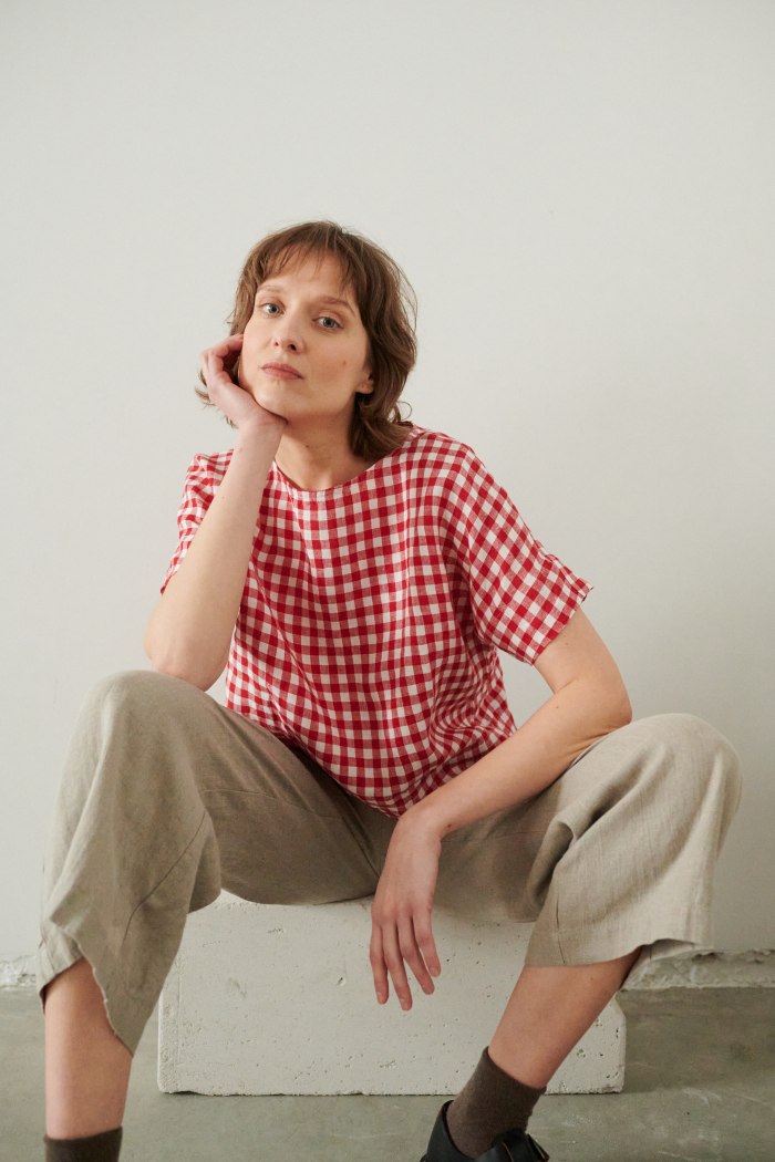 A woman in oversized summer red gingham linen top