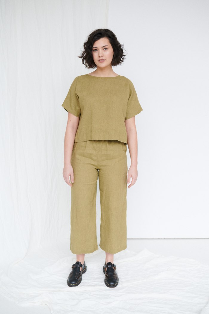 A woman in cropped olive green linen top