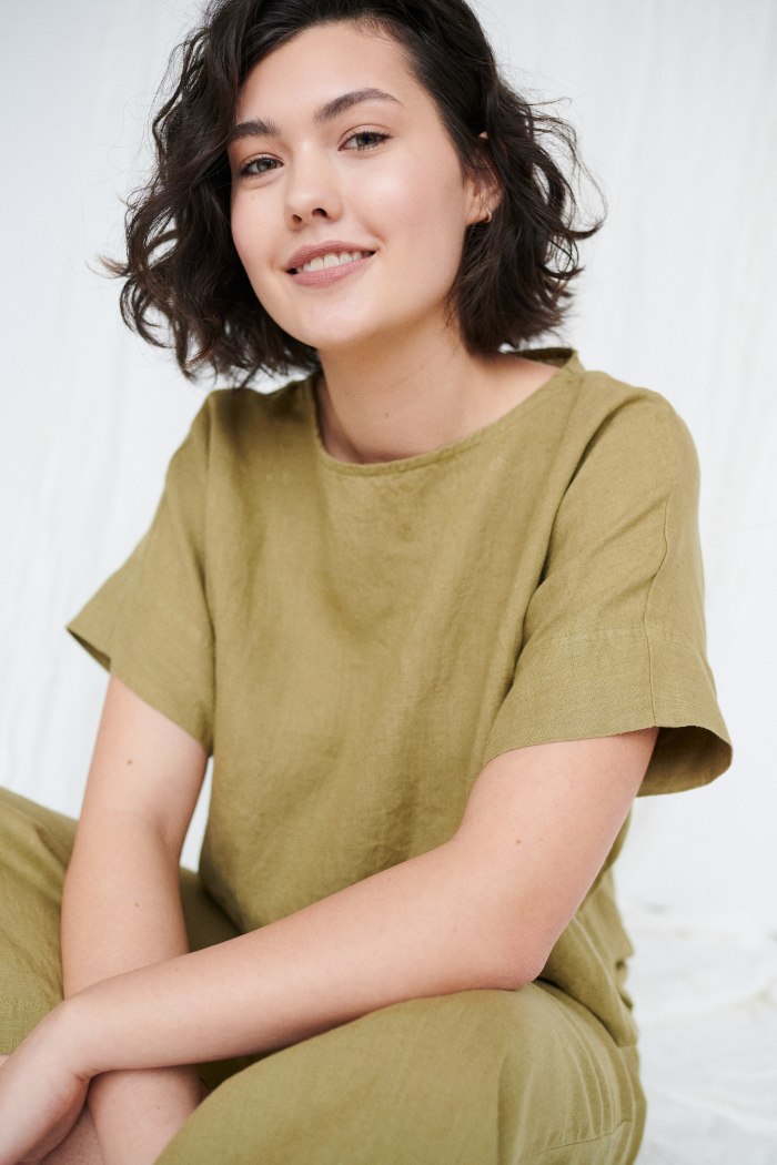 A woman wearing olive green organic linen top