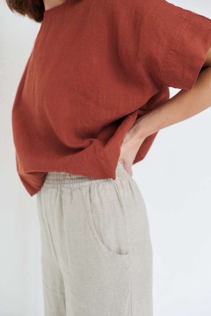 A woman in boxy oversized linen top in terracotta brown