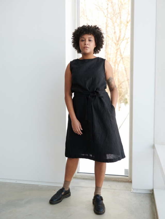 A model in a black midi dress with a belt