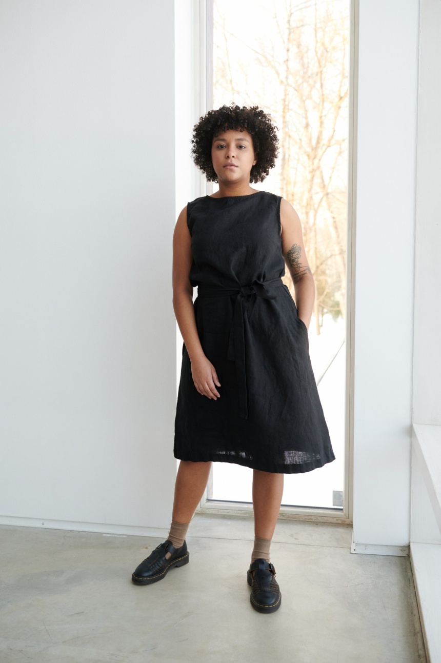 A model in a black midi dress with a belt