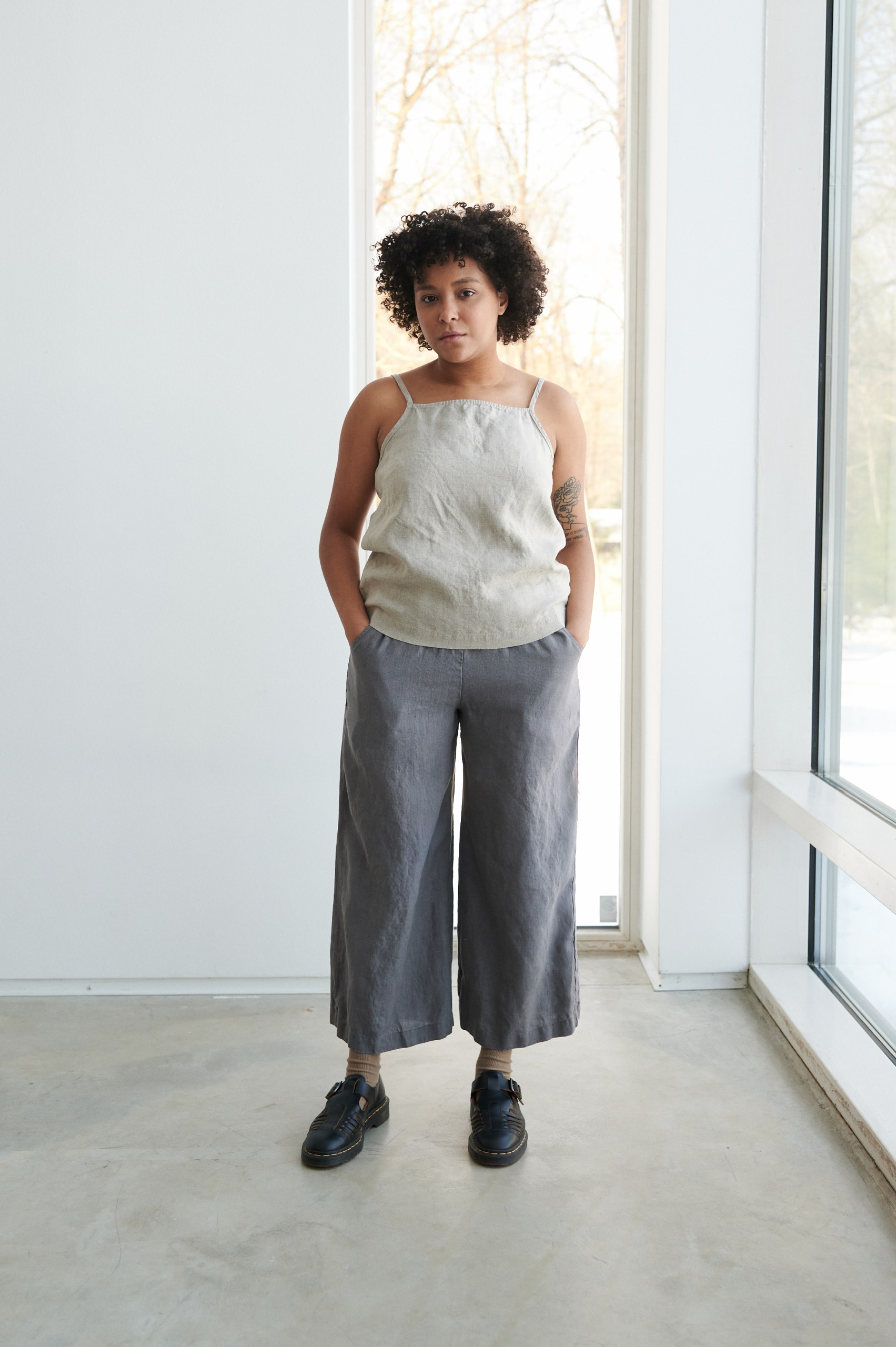 A woman standing in graphite grey relaxed linen pants