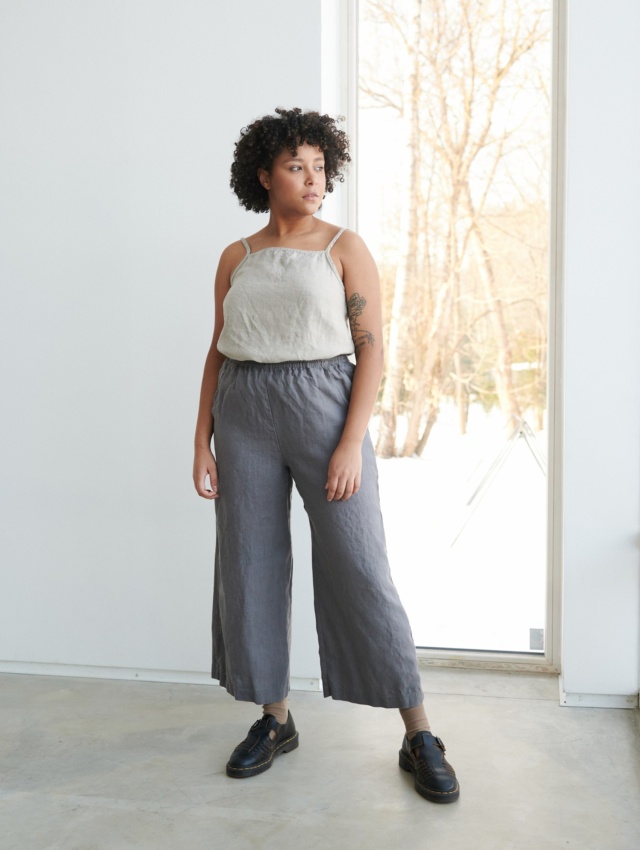 A model wearing dark grey wide leg trousers