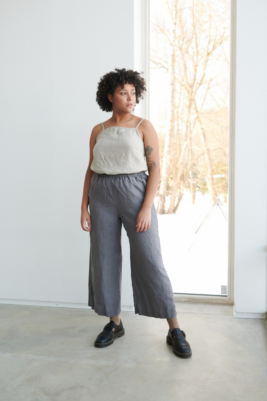 A model wearing dark grey wide leg trousers