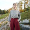 A woman wearing dark red linen trousers