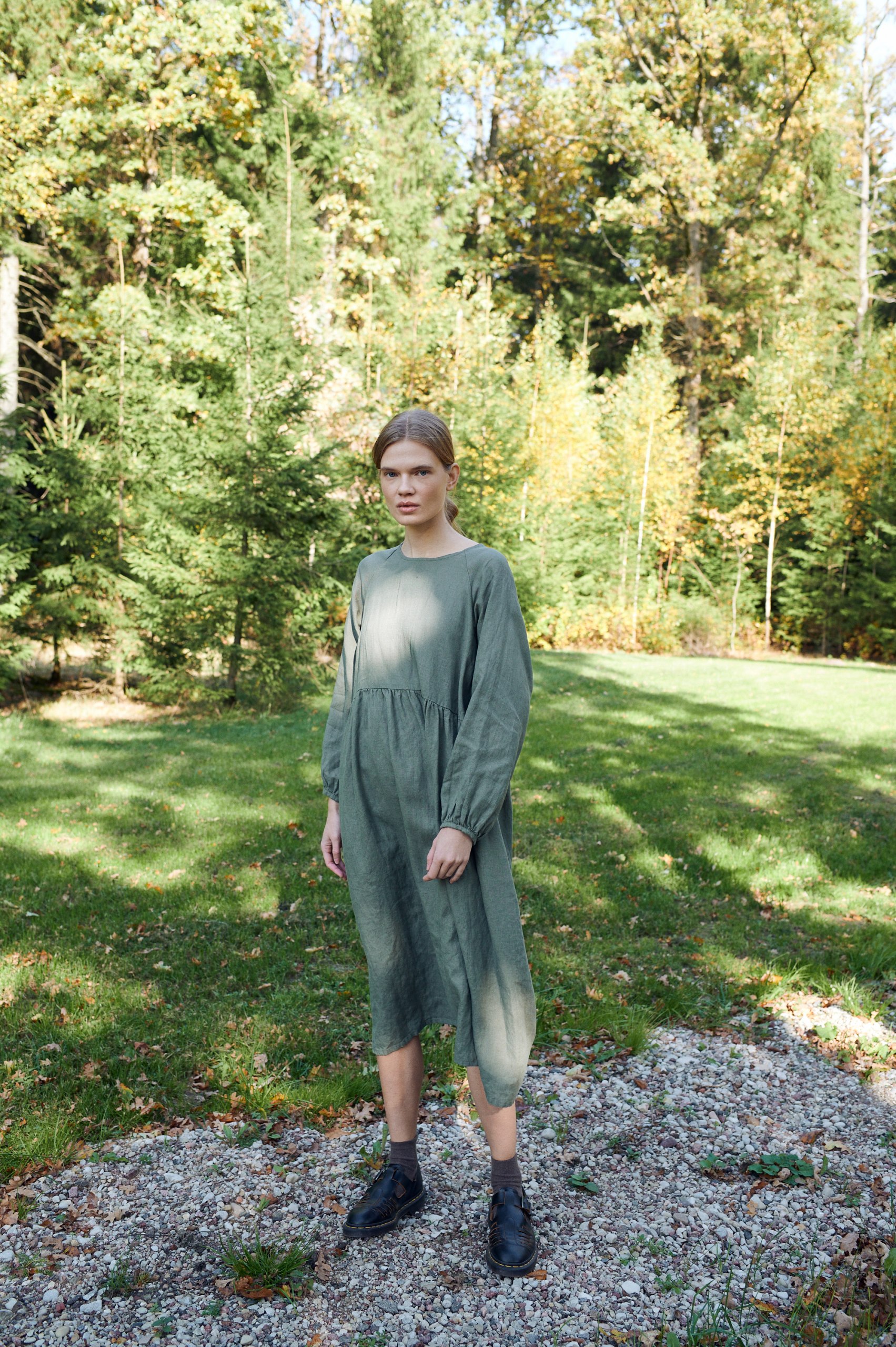 A model in long sleeve pine green linen dress