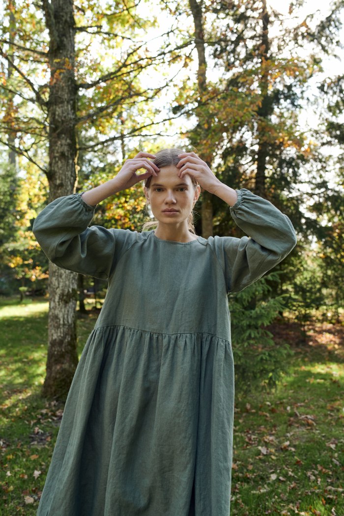 A woman in pine green long sleeve linen dress