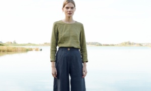 A model standing in barrel shape linen pants in dark grey