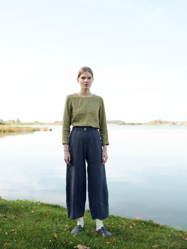 A model standing in barrel shape linen pants in dark grey