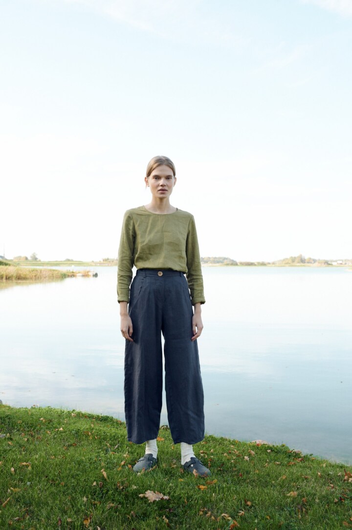 A model standing in barrel shape linen pants in dark grey