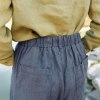 The elastic waistband of dark grey linen trousers