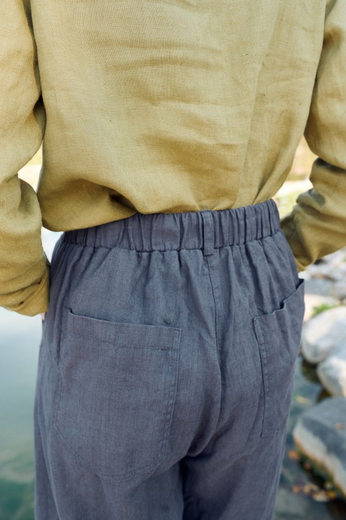 The elastic waistband of dark grey linen trousers