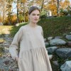 A model in long sleeve oversized linen beige dress