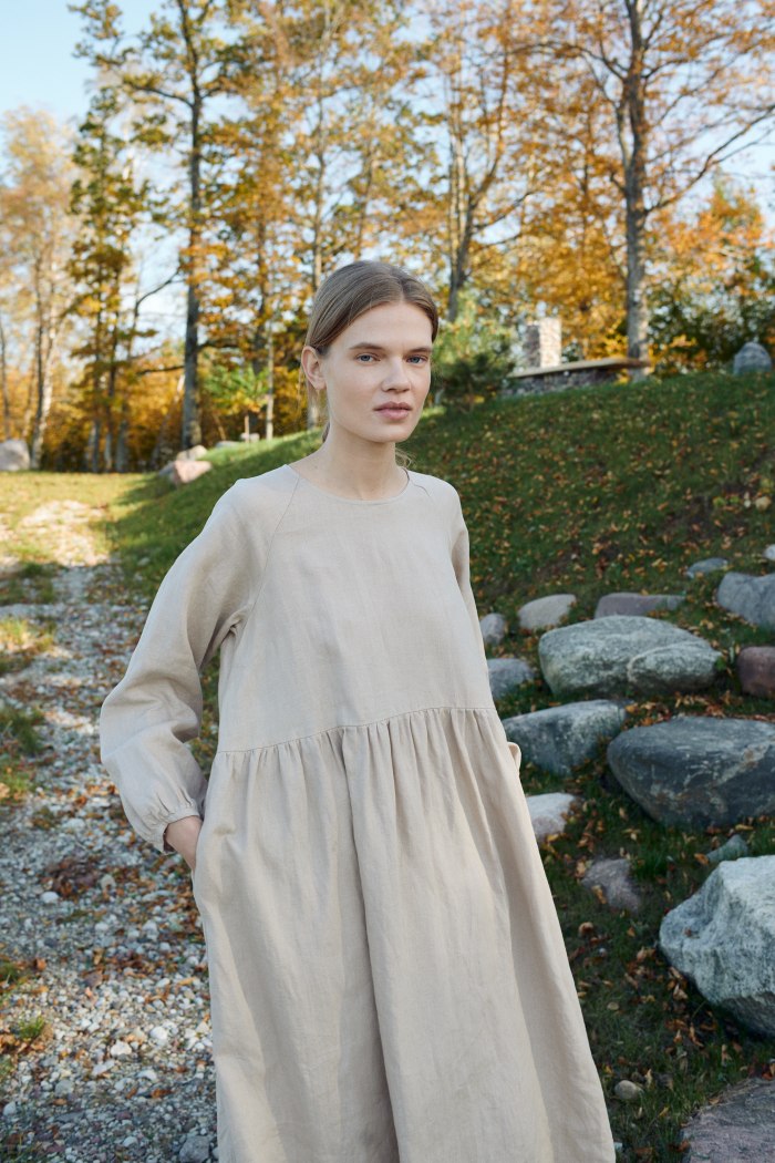 A model in long sleeve oversized linen beige dress