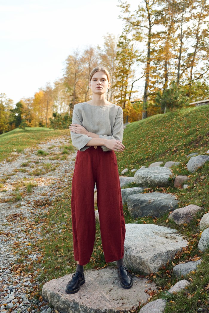 A model in dark red high waisted linen trousers
