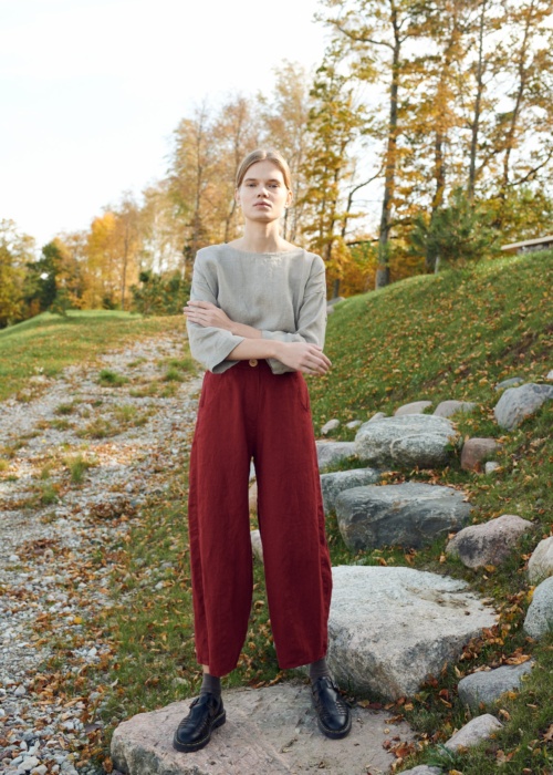 A model in dark red high waisted linen trousers