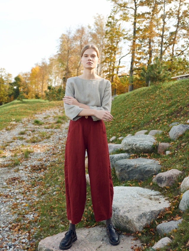 A model in dark red high waisted linen trousers