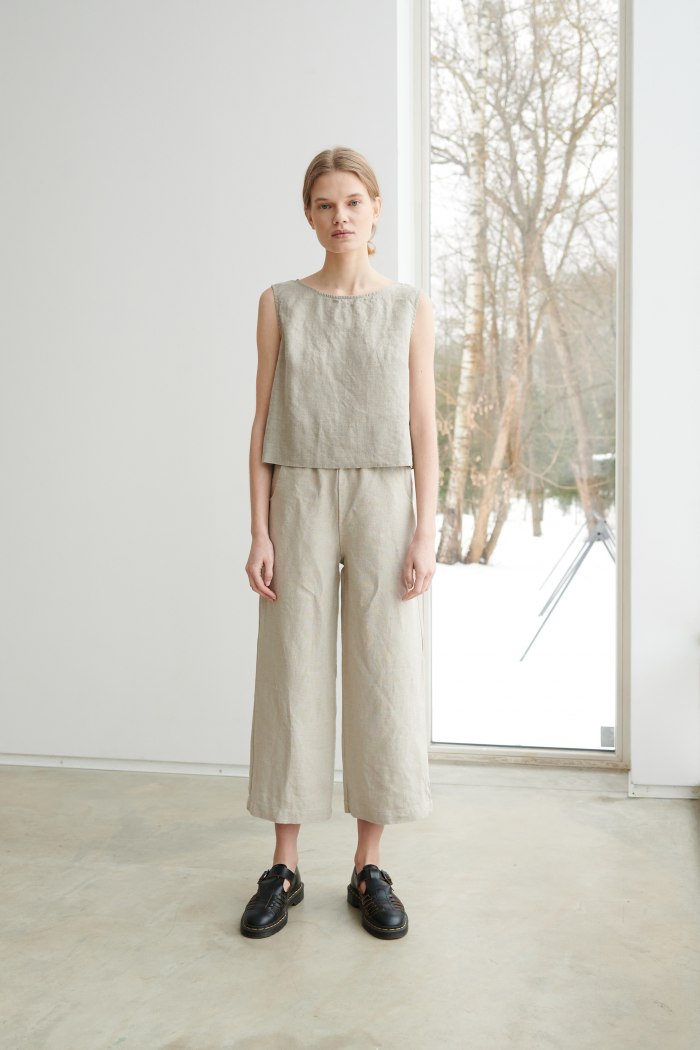 A woman standing in natural grey wide leg linen trousers