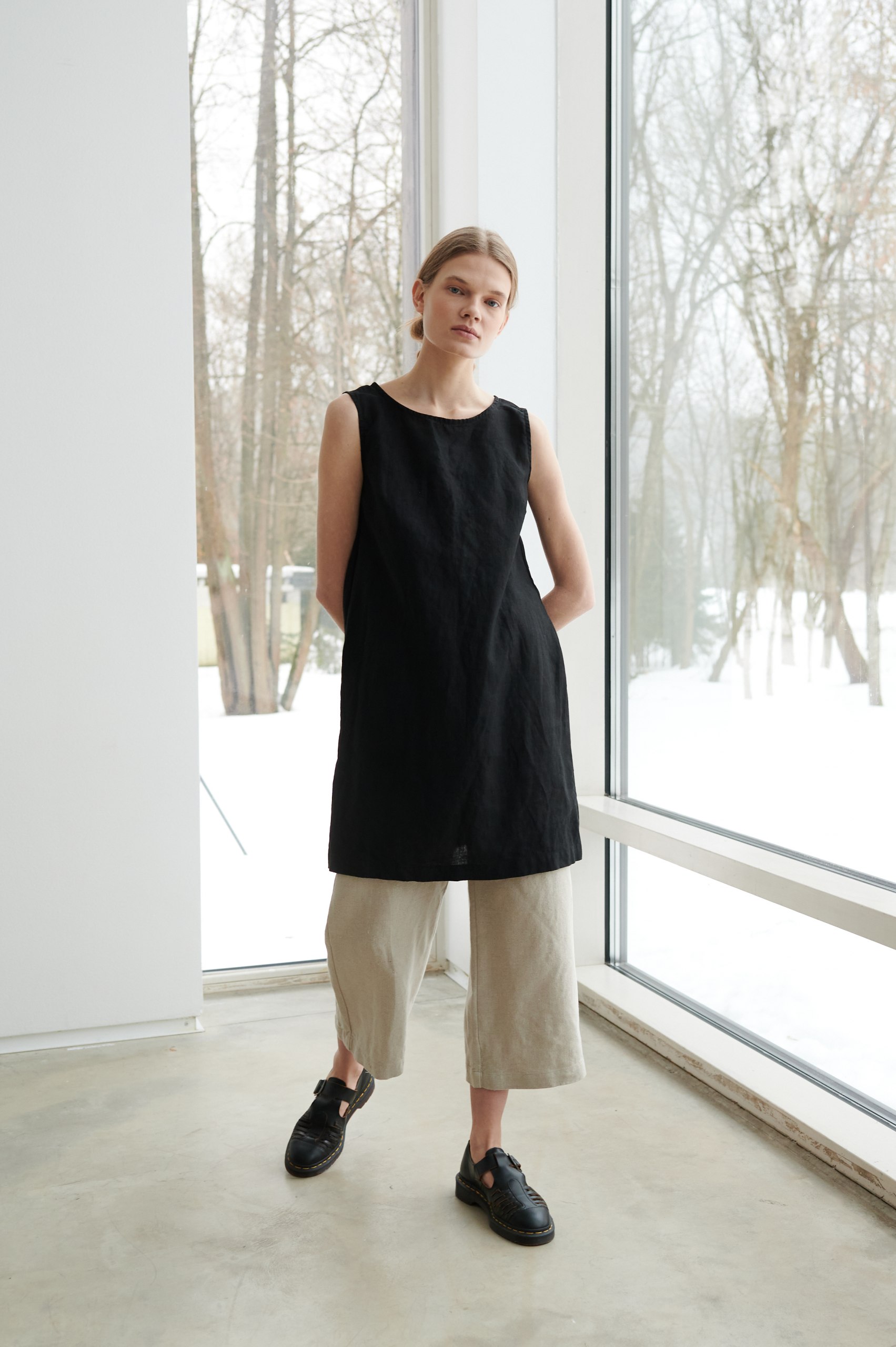 Model wearing sleeveless black linen dress