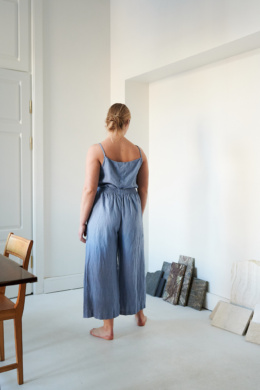 The back of a model wearing wide leg blue linen trousers