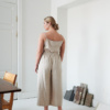 The back of the model wearing relaxed beige linen pants