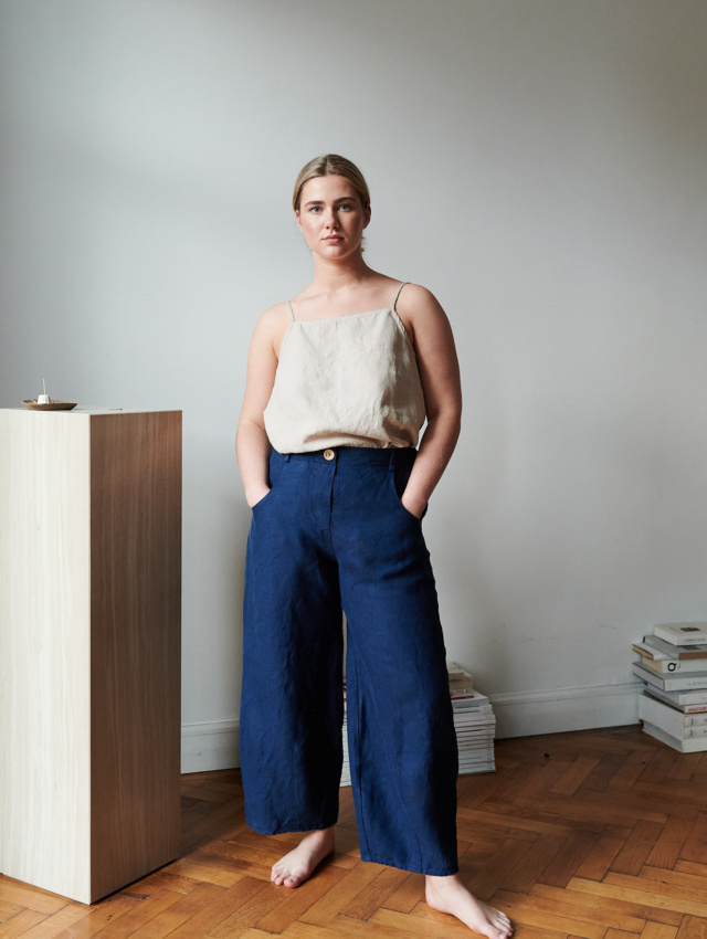 A model in dark blue heavy linen trousers