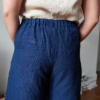 The back pockets of navy blue heavy linen pants